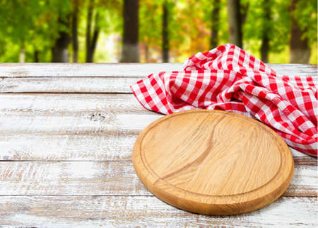 pizza desk checkered tablecloth on a wooden table on blurred forest backgroundの写真素材