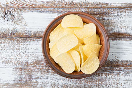 chips in a plate top view, wooden table, foodの写真素材
