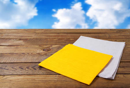 colored napkin, wooden table on blurred sky backgroundの写真素材
