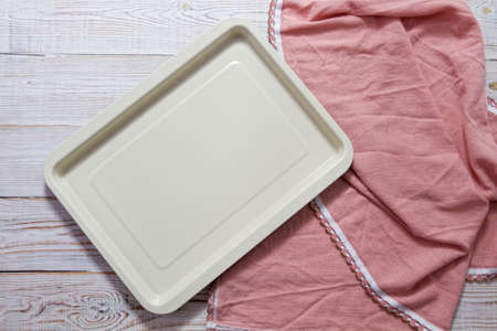Empty baking tray with pink tablecloth top view on tableの写真素材
