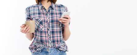 Pretty young woman holding smart phone, using device, wearing stylish glasses, smiling, holding a...