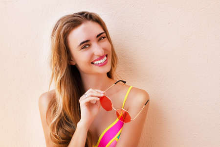 Happy summer woman in swimsuit and red sunglasses.の写真素材