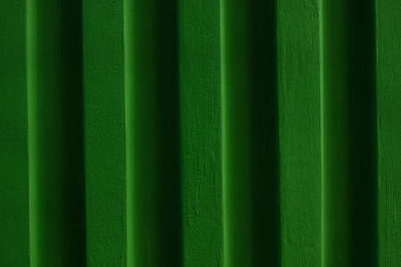 Green brick wall background.Grassy surface of color building.