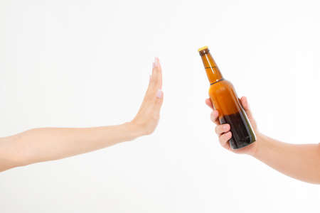 female hand reject a bottle of beer isolated on white background.anti alcohol concept. Copy spaceの写真素材