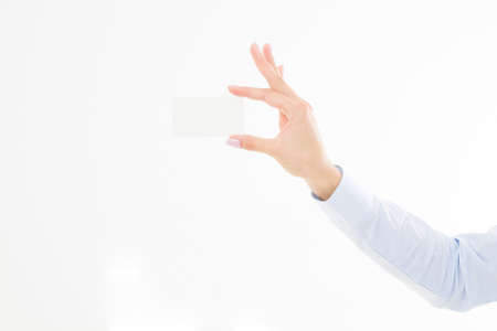 female hand holding business card isolated on white background. copy spaceの写真素材