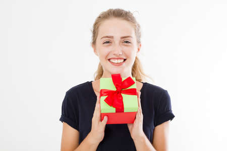 Portrait of a smiling girl, woman holding stack of gift boxes isolated on white background. Holiday...