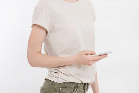 Girl holding white phone. Cellphone isolated on white clipping path inside. Online shopping. Top...