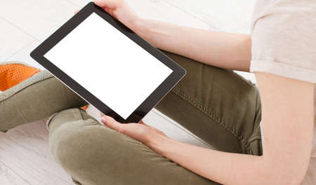 teen woman girl using a tablet pc sitting on the floor in a living room , touching blank screen