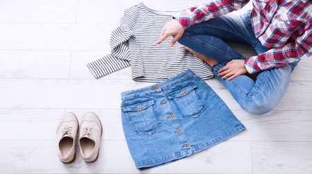 Fashion clothes and teenager sitting on white wooden floor. top view