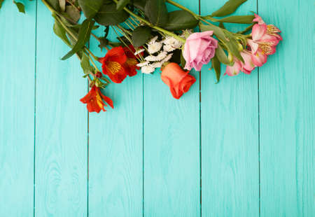 Bouquet of flowers on blue wooden background. top view and copy space.