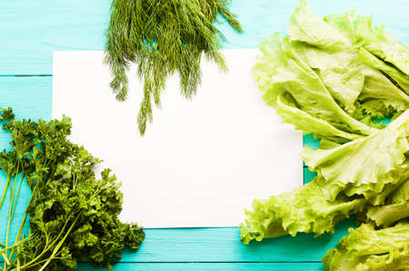 Different vegetables on kitchen table with recipe list and copy space. Top view and selective focus