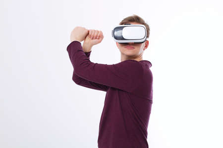Young man using a VR headset and playing in virtual reality isolated on white background. copy space...