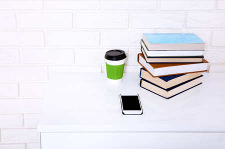 Business workplace with accessories on white table near brick wall with copy space.
