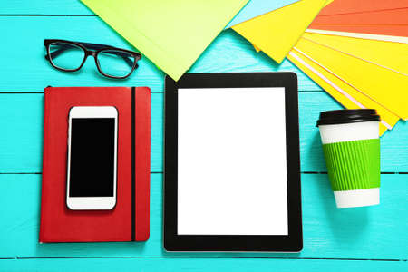 Electronic devices on blue wooden background. Cup of coffee and work accessories. top view