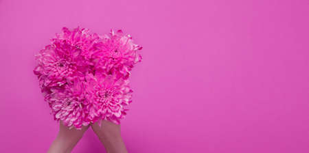 Summer flowers composition with girl hand isolated on pink background. mother and women day. Valentine holidays concept. Top view and copy space. banner and mockup. flower seasonの写真素材