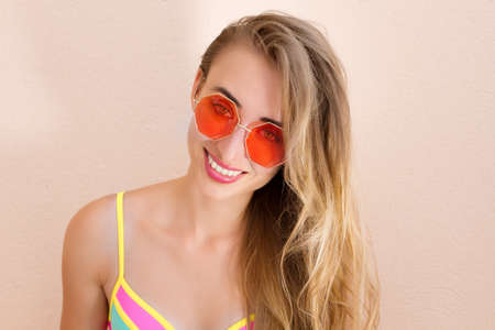 Close Up Of Happy Girl in pink sunglasses isolated. Summer holidays and fun time weekend. summertime concept. Smiling young woman in fashion swimsuit. selective focus. Beach Summer outfit. copy spaceの写真素材