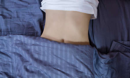 Healthy nutrition and belly health concept. Close up of woman flat stomach. Girl in bed with hungry...