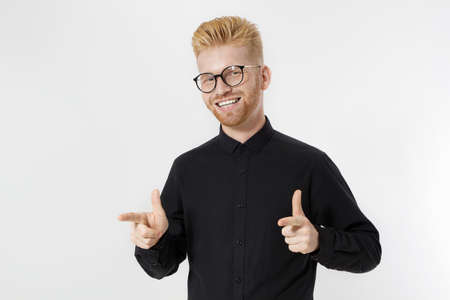 Happy Stylish guy in black shirt and glasses pointing copy space. Successful young man Entrepreneur...