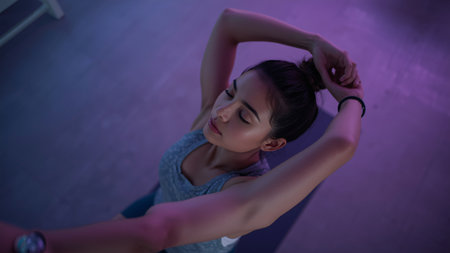 Portrait of a young woman doing stretching exercise in a gym.の素材