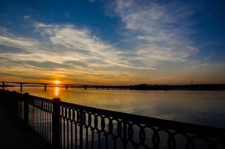 Sunset over the river above the bridgeの写真素材