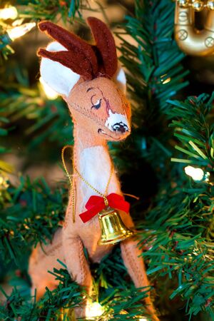 Xmas deer with a bell on its neck on the treeの写真素材