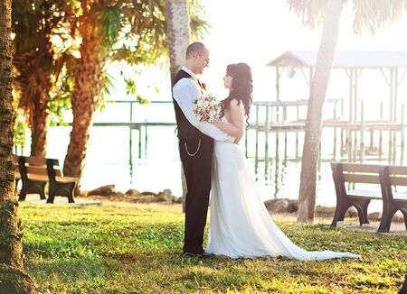 Bride and groom looking happy on the beach の写真素材