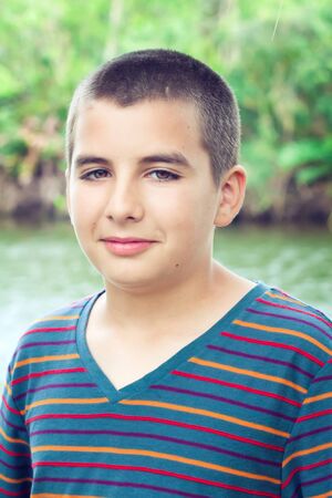 Portrait of young boy in the park looking at the cameraの写真素材