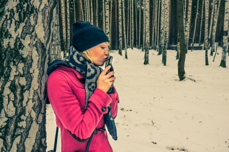 Beautiful woman in love kiss her phone in a parkの写真素材