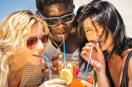 Closeup of happy multiethnic friends drinking cocktails