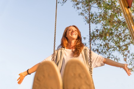 Pretty girl having fun on swingの写真素材