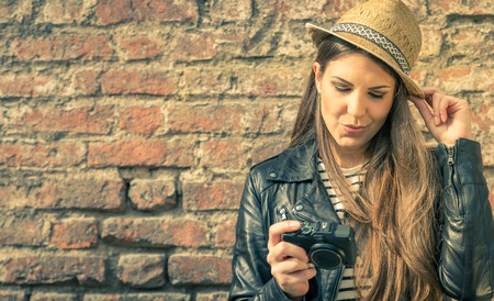 Pretty girl with her camera - Beautiful model with urban style dresscode looking at camera,copy...