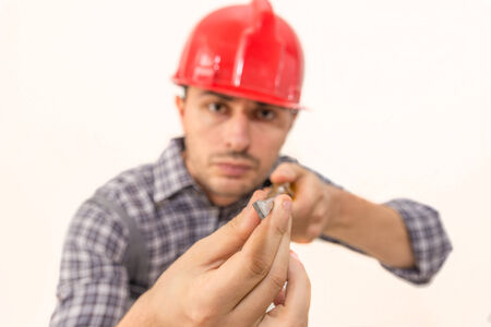 Electrician using a screwdriver isolated on whiteの写真素材