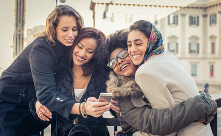 friends laughing and watching funny videos togetherの写真素材