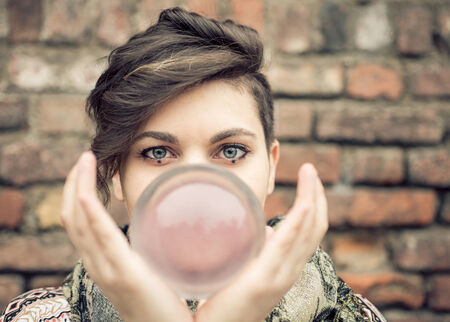 Portrait of young beautiful girl with blue eyes balancing a crystal ball on the hand - Woman performing contact jugglingの写真素材