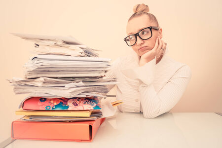 Inquiet business woman looking at her stack of documents - Secretary deluged by bills