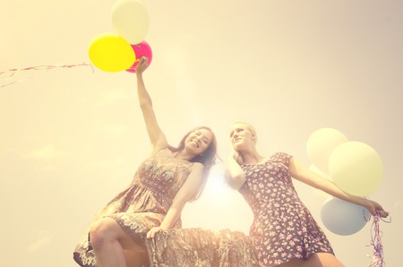 Two women playing with air balloons - Freedom,happiness,summer conceptsの写真素材