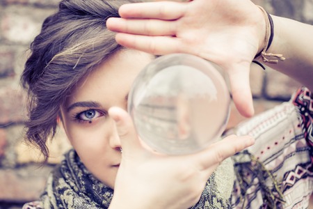 Portrait of young beautiful girl with blue eyes balancing a crystal ball on the hand - Woman performing contact jugglingの写真素材