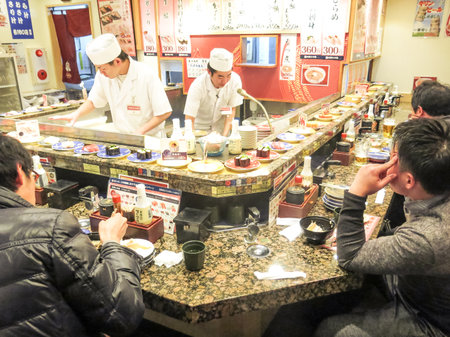 TOKYO,JAPAN - FEBRUARY 11,2015: people eating in a Sushi restaurant in Tokyo.Sushi is a traditional japanese speciality known all over the world.のeditorial素材