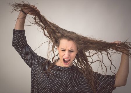 crazy woman pulling hair. concept about feelings, emotions , behavior and peopleの写真素材