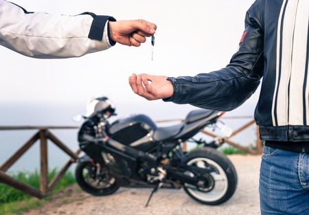 key exchange. Motorcycle concept. friends exchanging the bike key.の写真素材