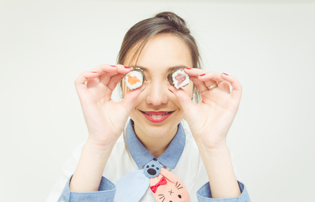 sushy eyes. woman playing around with sushy pieces. cocept about food and peopleの写真素材