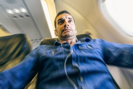 Airplane passenger in shock while the plane is in a turbolence areaの写真素材