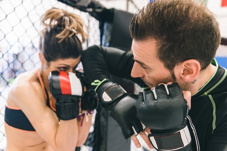 mma training. couple making sparring in the mma cage. concept about fighting, fitness and sportの写真素材
