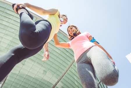 two runners making stretching before running. concept about urban running, sport, fitness and people