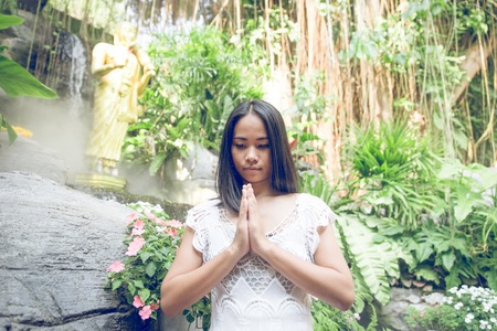 thai woman praying in a buddhist  templeの写真素材