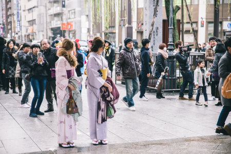 Tokyo, Asakusa. February 8, 2015. Two girls in japanese typical dress. The kimono is the traditional japanese dress and means literally "something to dress"のeditorial素材