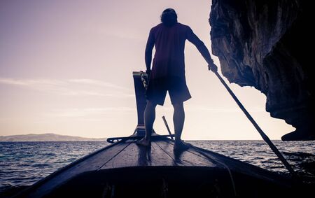Beautiful thai beach and landscape. Phi phi island view from the long tail boat with fisherman silhouetteの写真素材