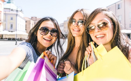 Three girls taking selfie and making shoppingの写真素材