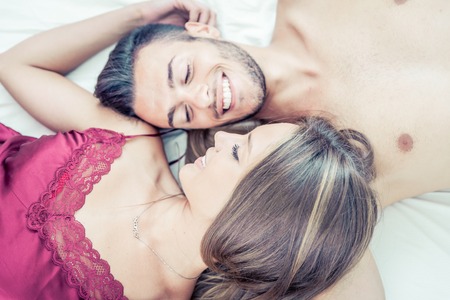 Happy couple sharing moments in bed. tenderness in the morningの写真素材