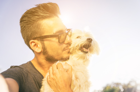 Young man taking selfie with his cute dog outdoor. Animals and love for themの写真素材